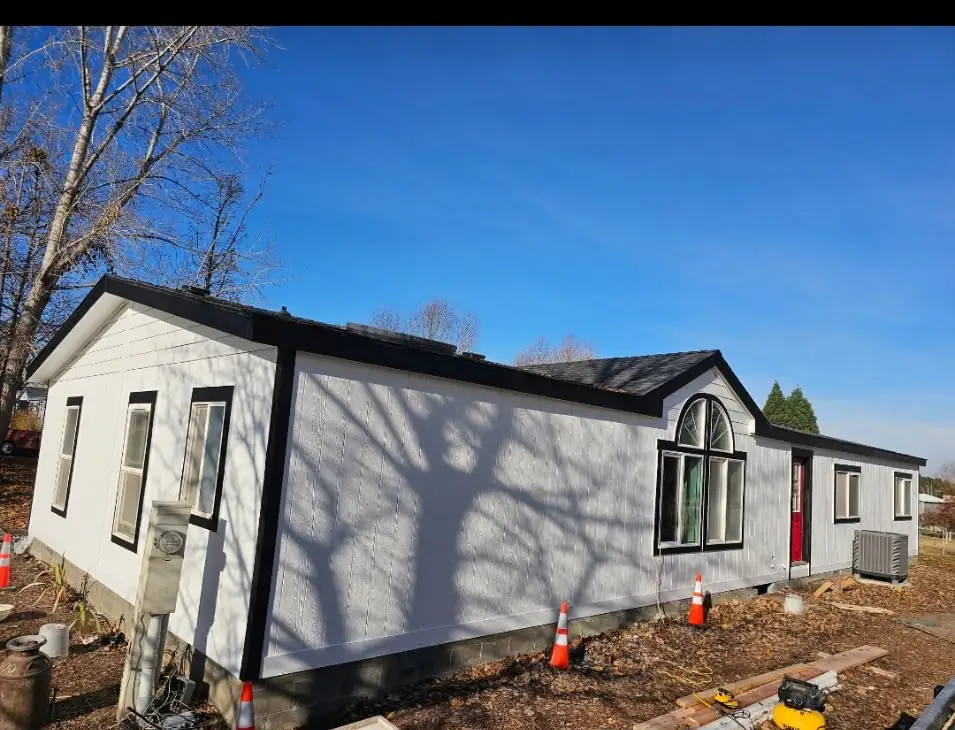 After: full exterior siding and roofline, new black-trimmed windows