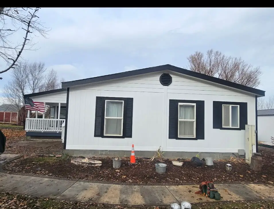 After: front of home with new siding, shutters, and roofline